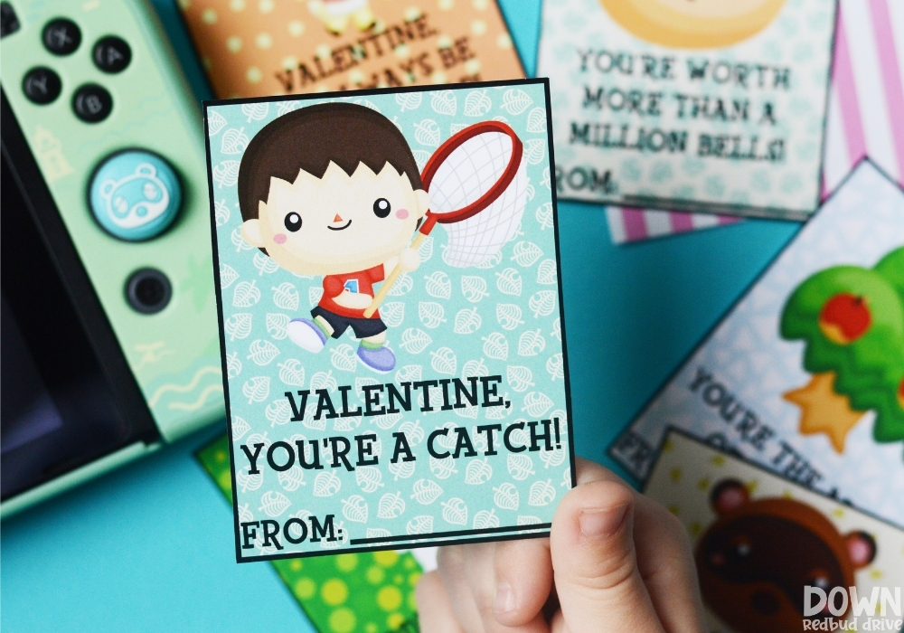 animal-crossing-valentines-wide-3 A child holding a valentine that says "Valentine, you're a catch!" on it.