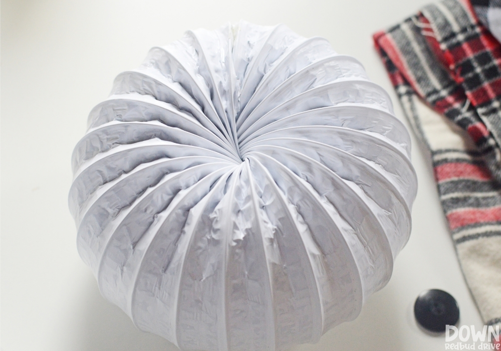 diy-dryer-vent-snowman-wide-2 A piece of white dryer vent duct formed into a circle.