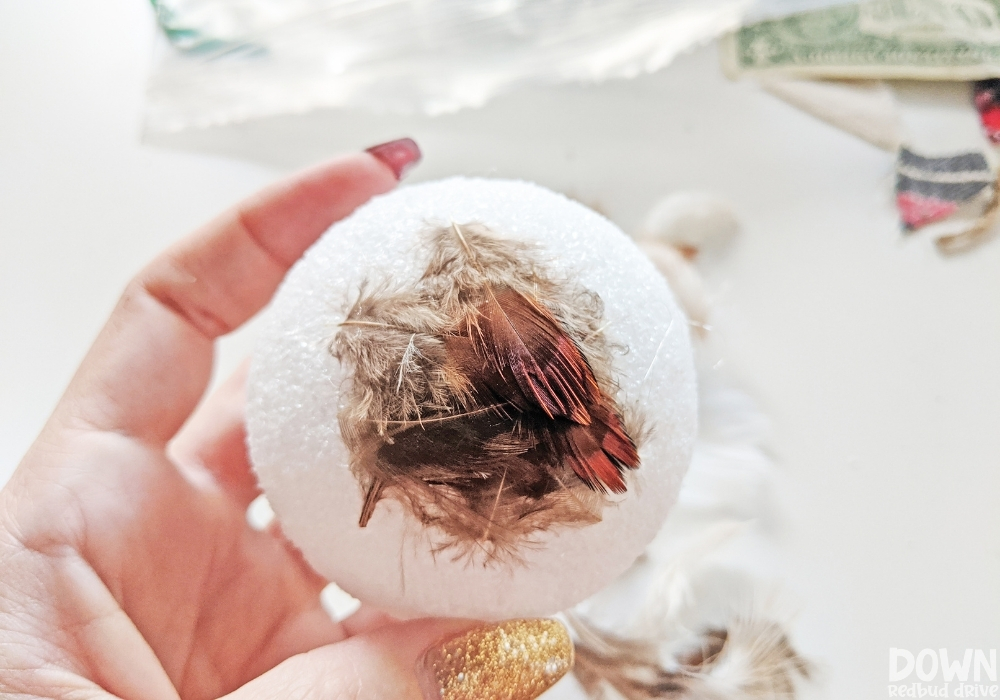 feather-ornament-diy-wide-3 Close up of feathers being attached to a foam ball.