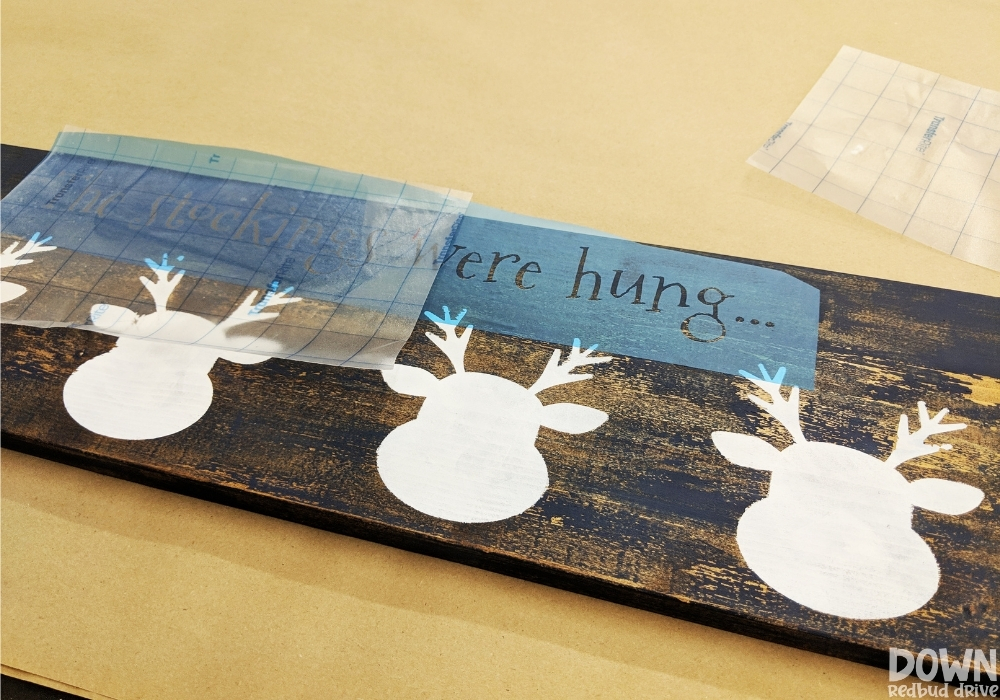 reindeer-stocking-holder-diy-wide-2 Overhead shot of a stencil being laid out onto a stocking holder.