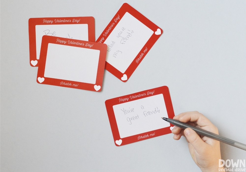 scratch-off-valentines-wide-3 A child writing a note on a blank etch a sketch card.
