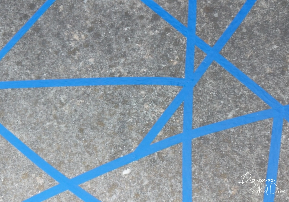 sidewalk-chalk-mosaic-3 geomatric shapes made from blue painter's tape on a sidewalk