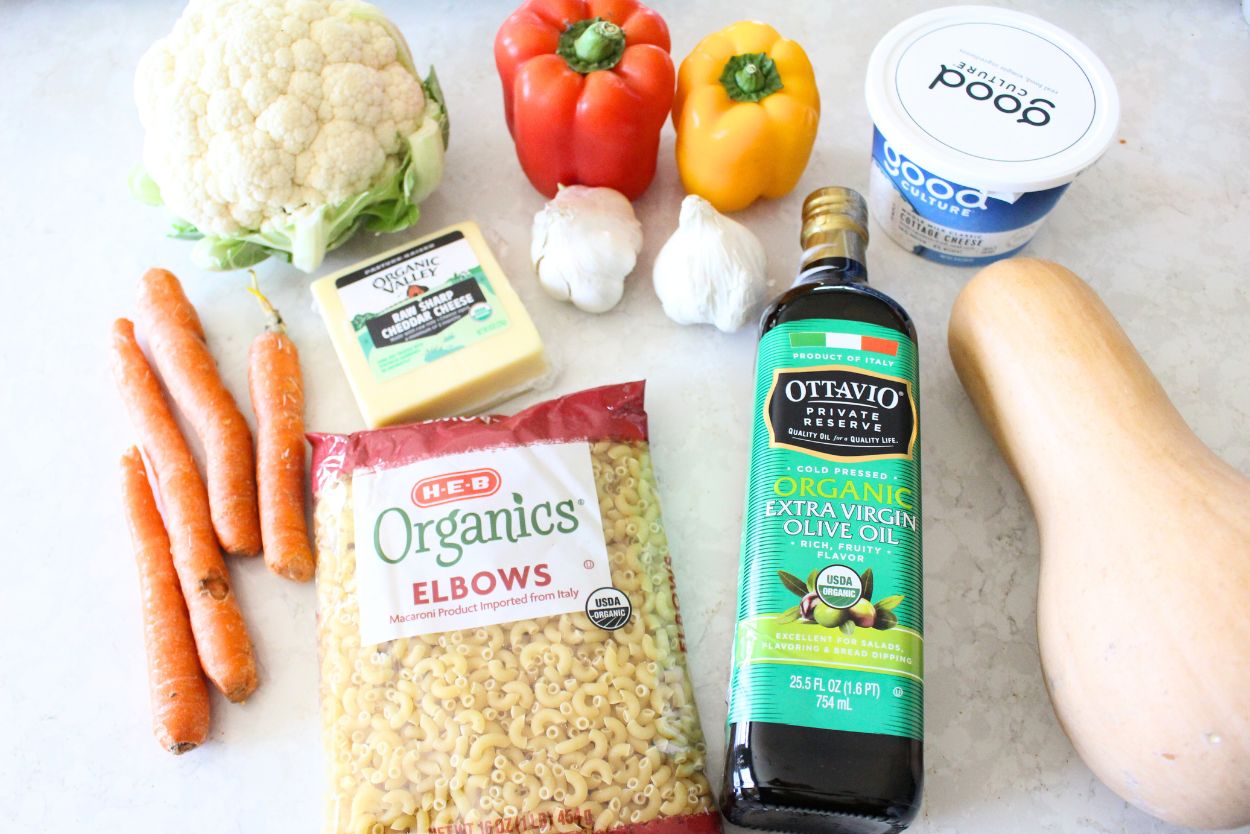 hidden-veggie-mac-and-cheese-recipe-ingredients Ingredients for hidden veggie mac and cheese including pasta, cauliflower, bell peppers, carrots, cheese, garlic, olive oil, cottage cheese, and butternut squash
